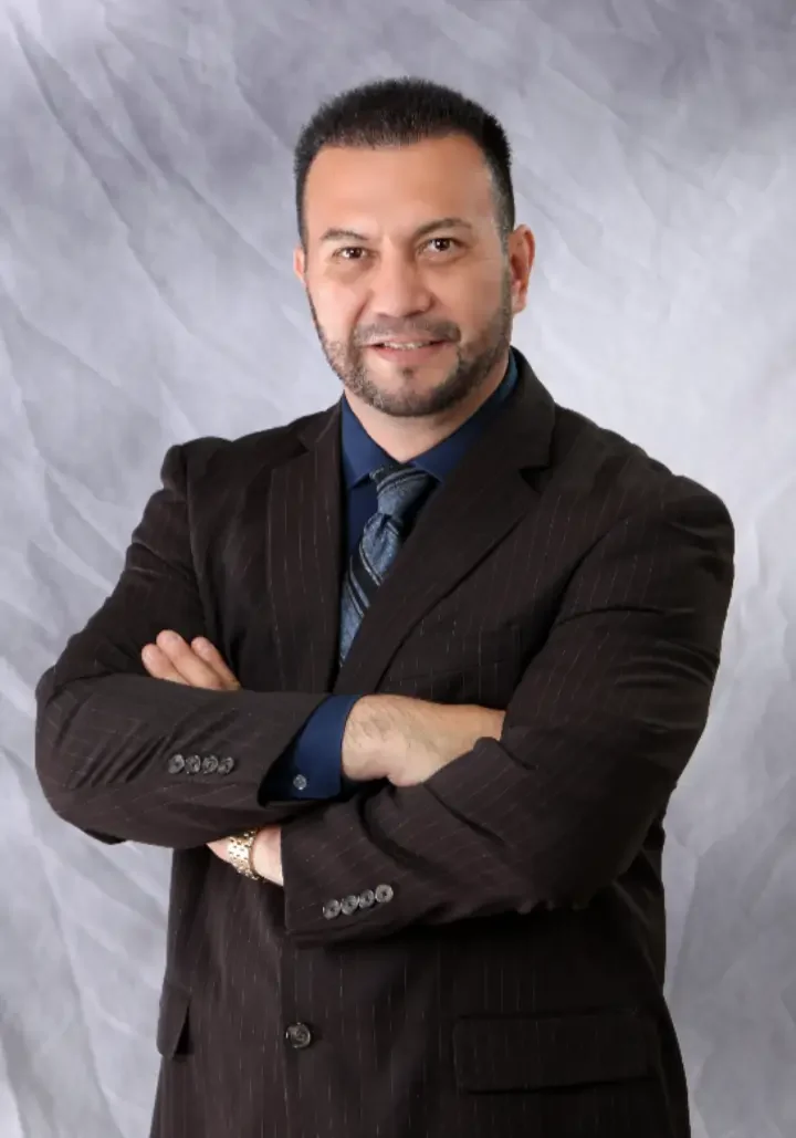 A man in a suit and tie with his arms crossed.